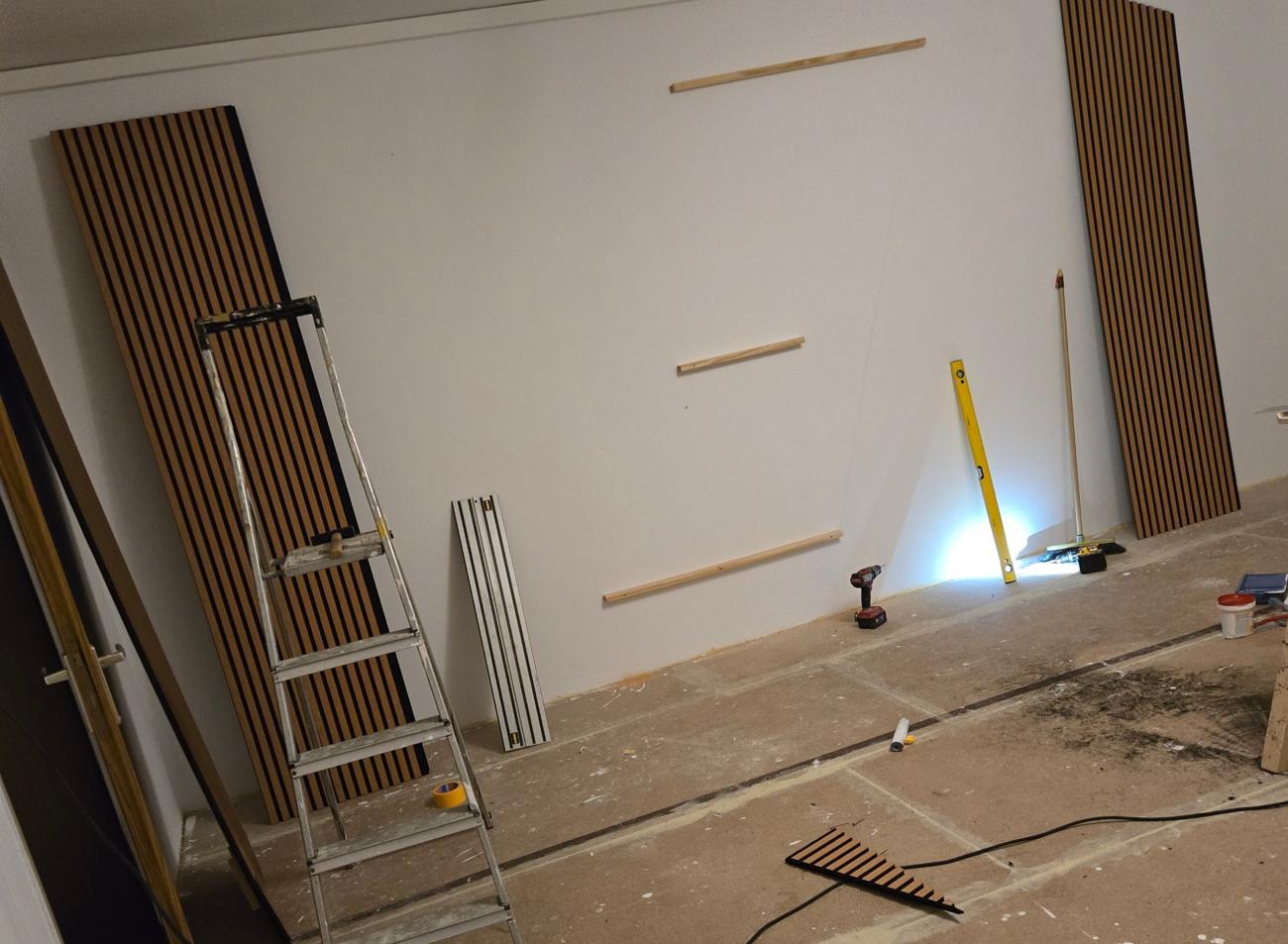 Leere Wand mit Unterkonstruktion, Paneele lehnen an der Wand