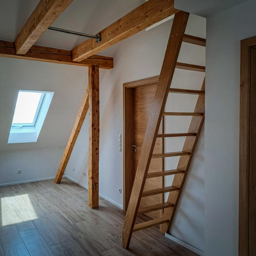 Leitertreppe aus Eiche im Dachgeschoss mit Holzbalken